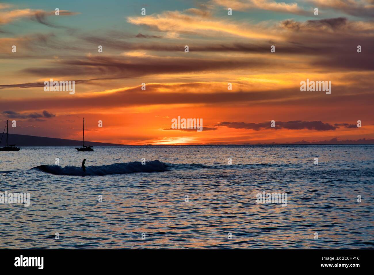 Ein eingesurfter Surfer bei Sonnenuntergang am Hafen von Lahaina auf Maui. Stockfoto