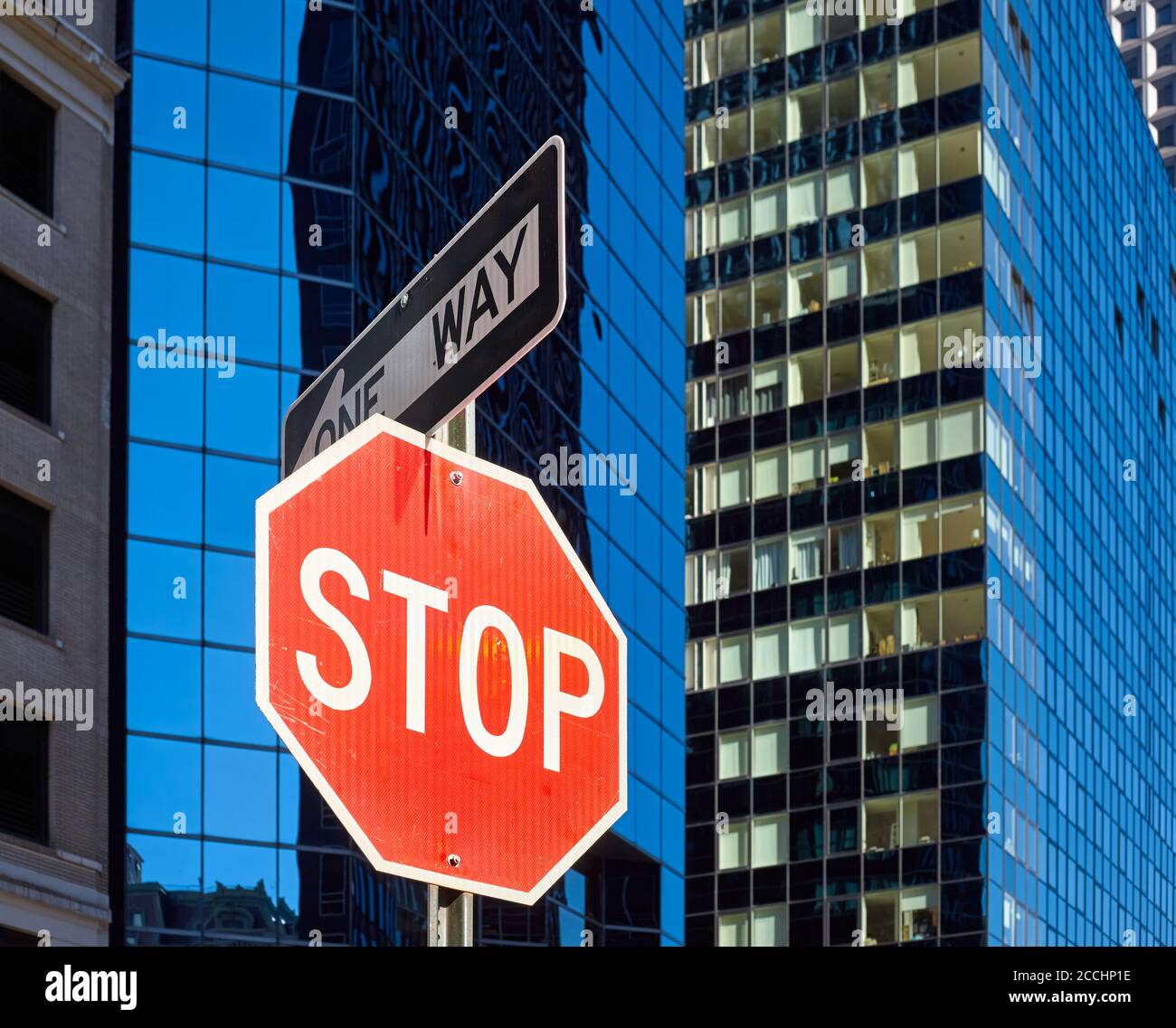 Stoppschild auf einer Straße von New York City mit verschwommenen modernen Gebäuden im Hintergrund, selektiver Fokus, USA. Stockfoto