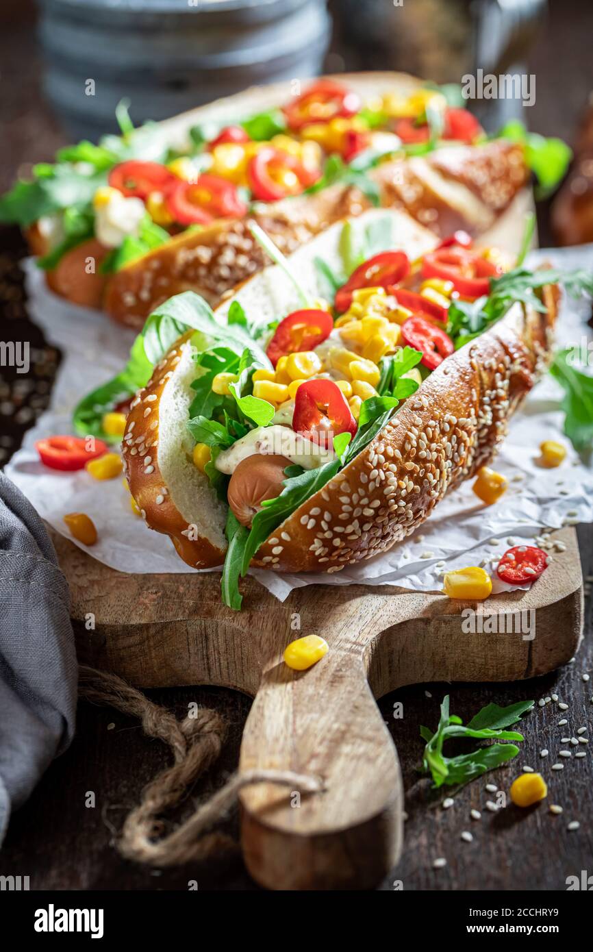 Leckere Hot Dogs mit Rucola, Mais und Chili Stockfoto