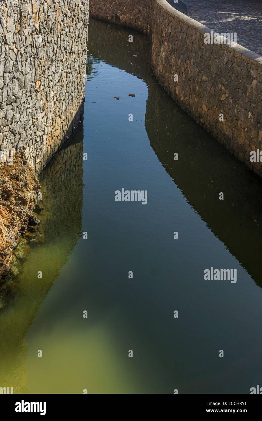 Wasser fließt durch umweltfreundliche Entwässerung Kanalsystem mit Steinen gebaut, vertikalen Schuss Stockfoto