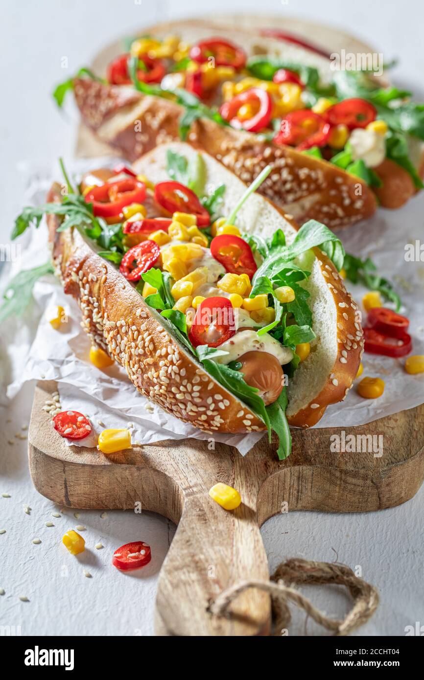 Leckere Hot Dogs mit Rucola, Mais und Chili Stockfoto