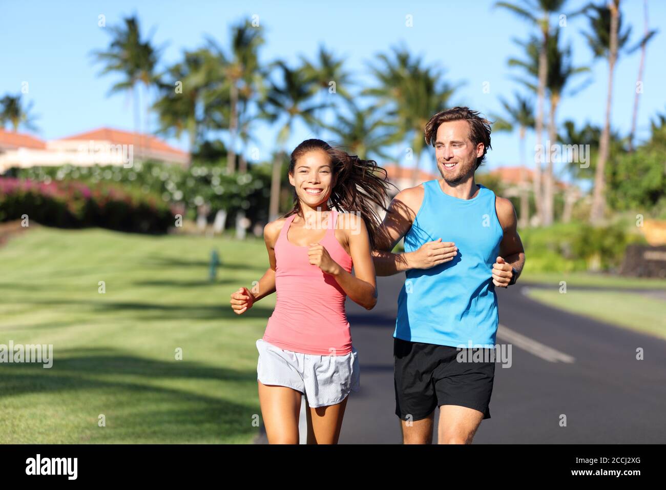 Fröhliche Läufer haben Spaß beim Laufen zusammen im Sommer draußen. Asiatische Frau mit Personal Trainer motivierend für Gewichtsverlust-Programm Stockfoto