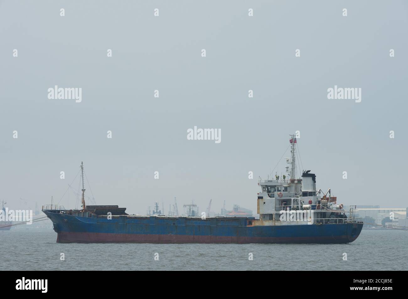 KAOHSIUNG, TAIWAN - CIRCA Juni, 2018:EIN großes Frachtschiff zieht in Richtung des Ausgangs des Hafens von Kaohsiung Stockfoto