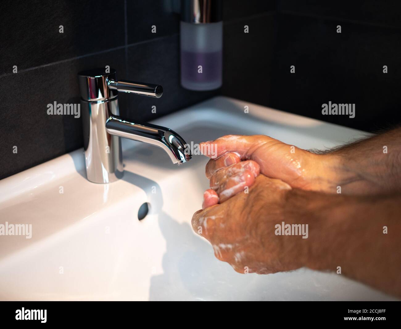Handwäsche Körperpflege Mann waschen Hände reiben Seife für 20 Sekunden folgenden Schritten, Reinigung der Handgelenke und Spülen unter Wasser zu Hause Badezimmer. Stockfoto