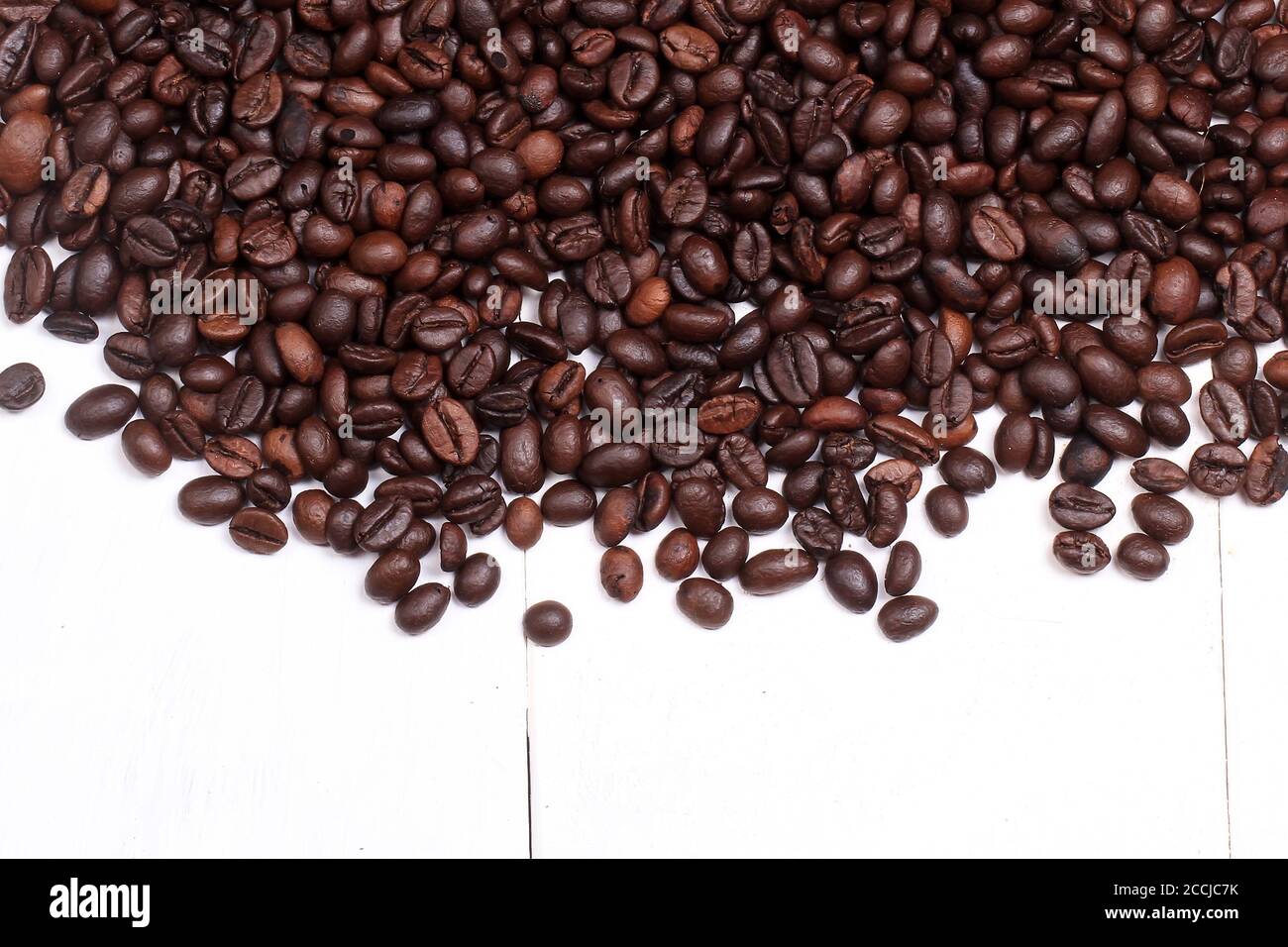 Kaffeebohnen auf einem weiß bemalten Holzsockel Stockfoto