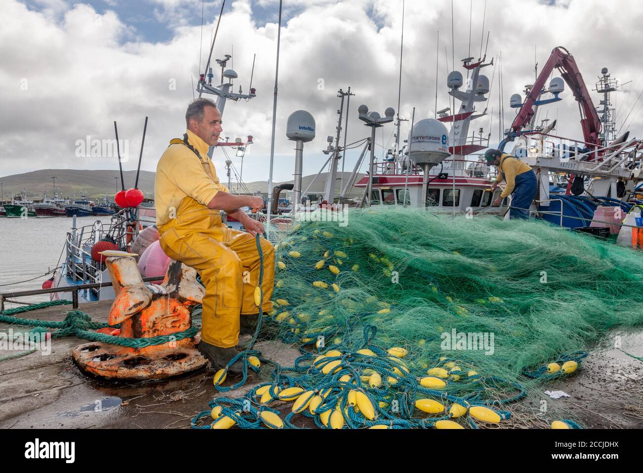 Castletownbere, Cork, Irland. August 2020. Fischer Edward Nova vom französischen Trawler Kalicoba, der Netze am Kai in Castletownbere, Co. Cork, Irland ausbessern konnte. - Credit; David Creedon / Alamy Live News Stockfoto