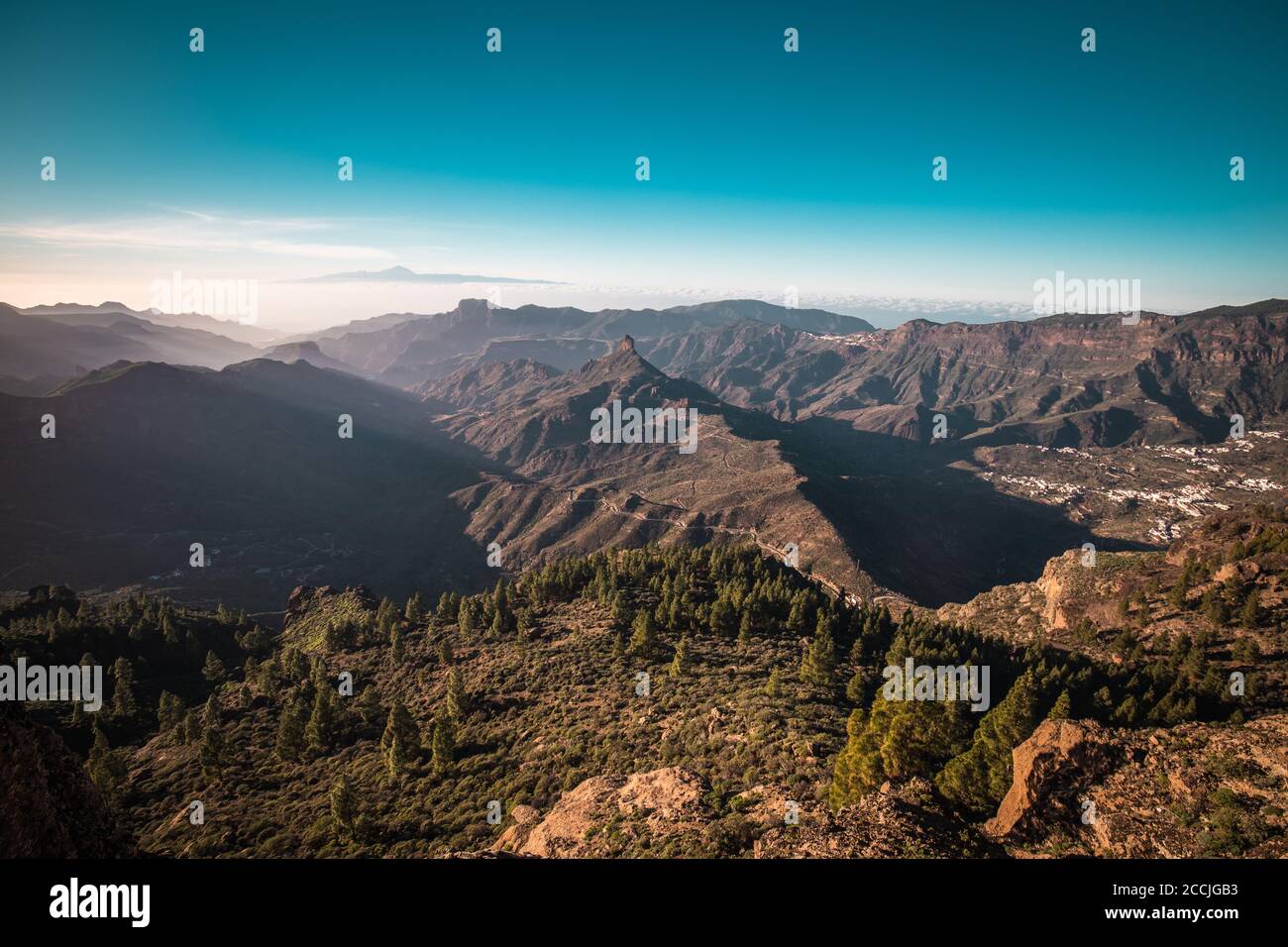 Ein Panoramablick auf einen Sonnenuntergang über dem Roque Nublo auf Gran Canaria, Spanien. Teneriffa ist im Hintergrund sichtbar. Stockfoto