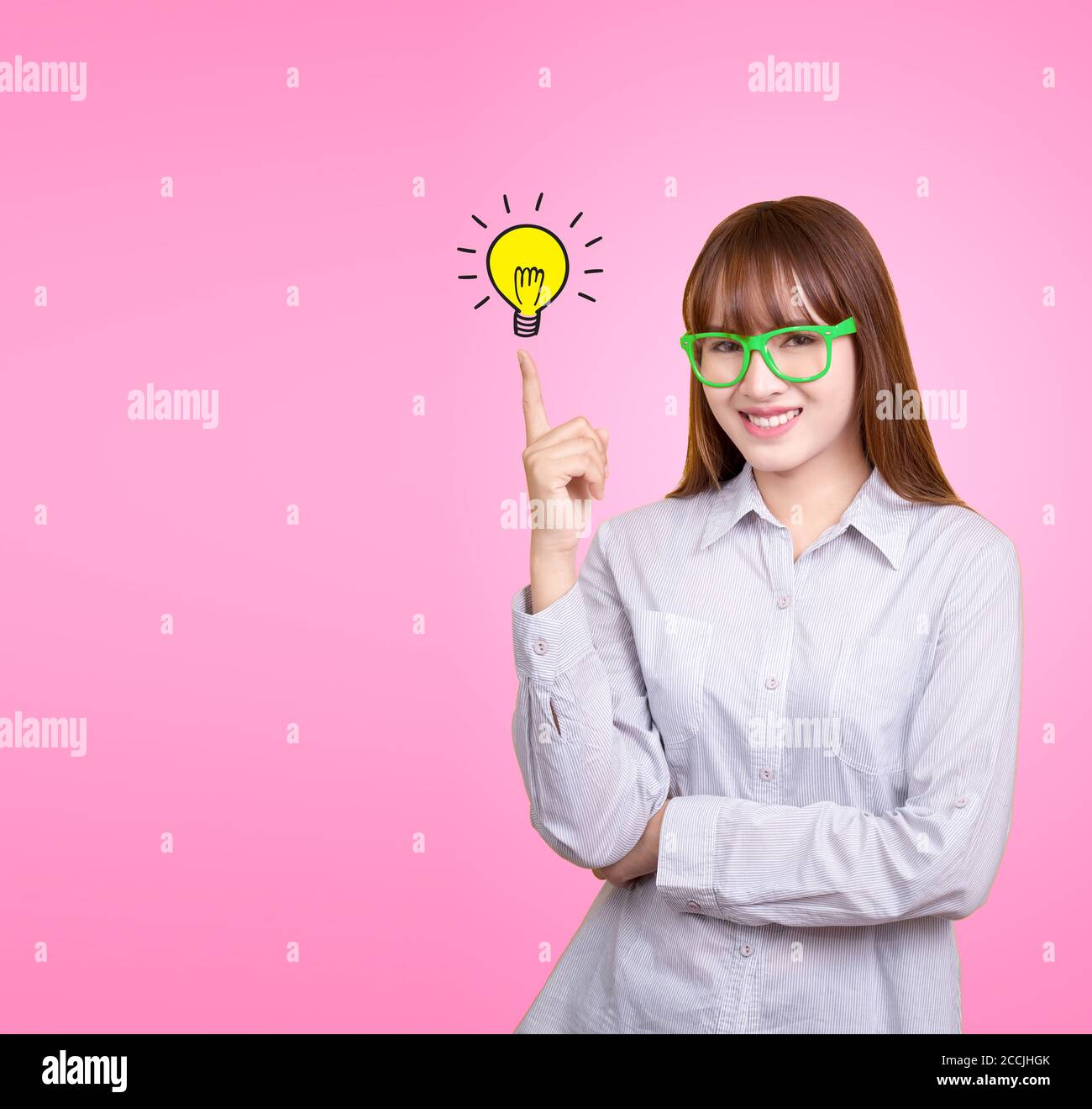 Business Asian Frau mit grünen Gläser stehen und haben Idee Lampe Lampe Lampe Licht auf Frauen Fingerspitze rosa Hintergrund, für Ihr Design für Poster und Adverti Stockfoto