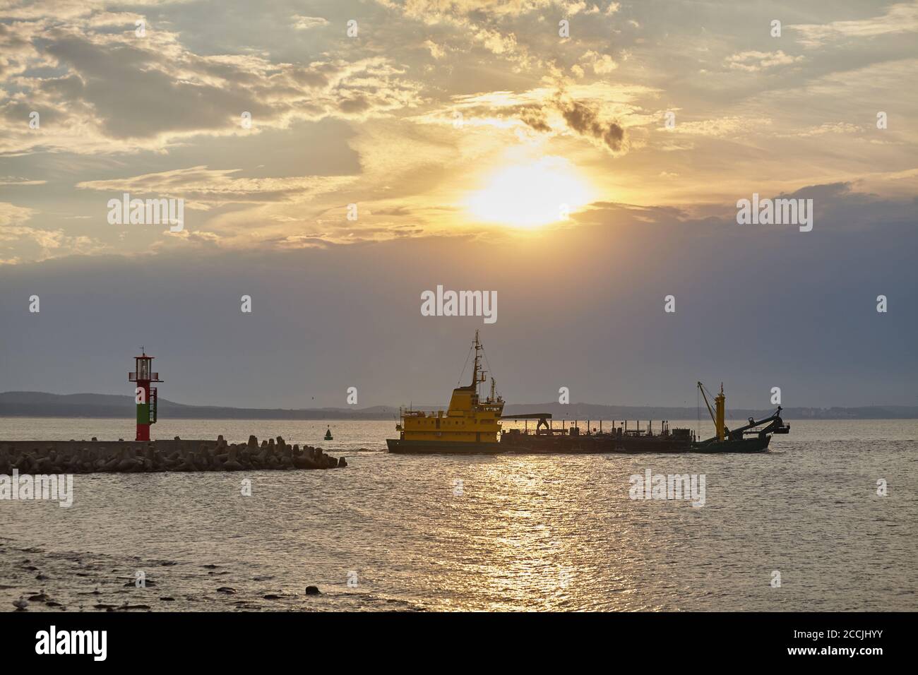 Schiff verlässt Hafen bei Sonnenuntergang, Swinoujscie, Polen. Stockfoto