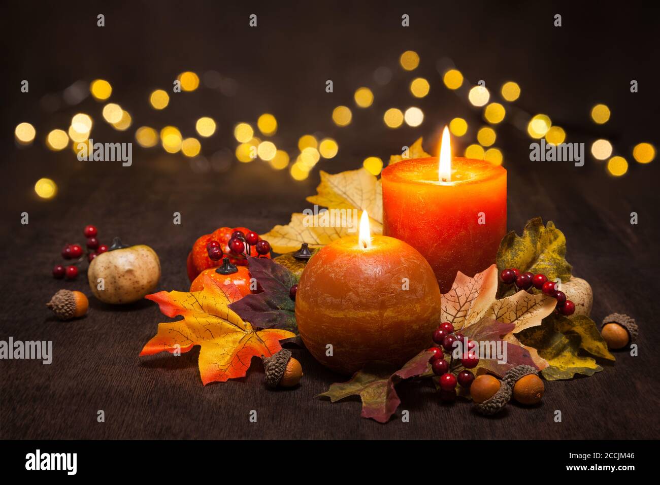 Herbstarrangement mit Kerzen, Herbstblättern und Sonnenblumen. Stockfoto