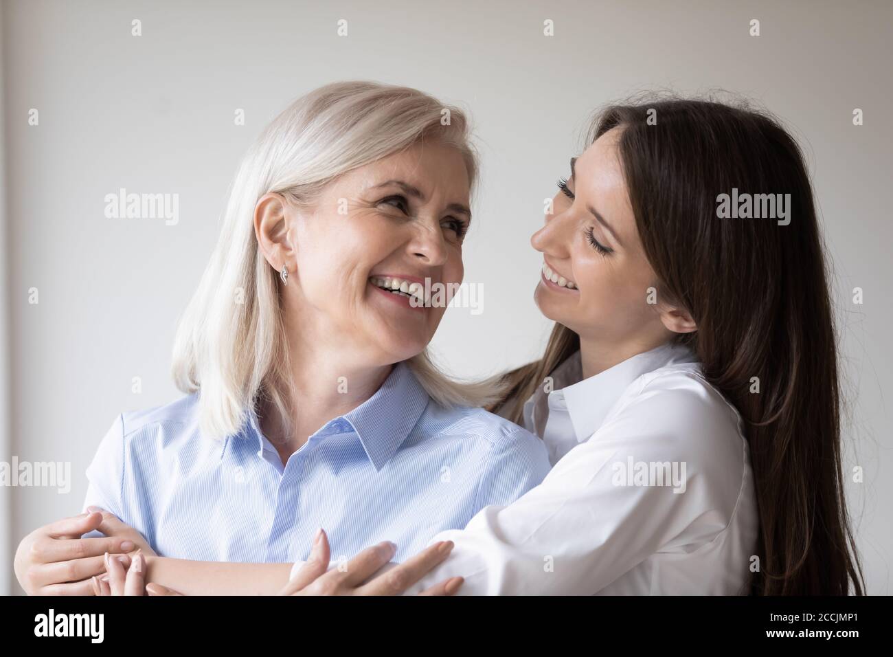 Glückliche Erwachsene Tochter umarmt ihre Mutter mit Liebe Stockfoto
