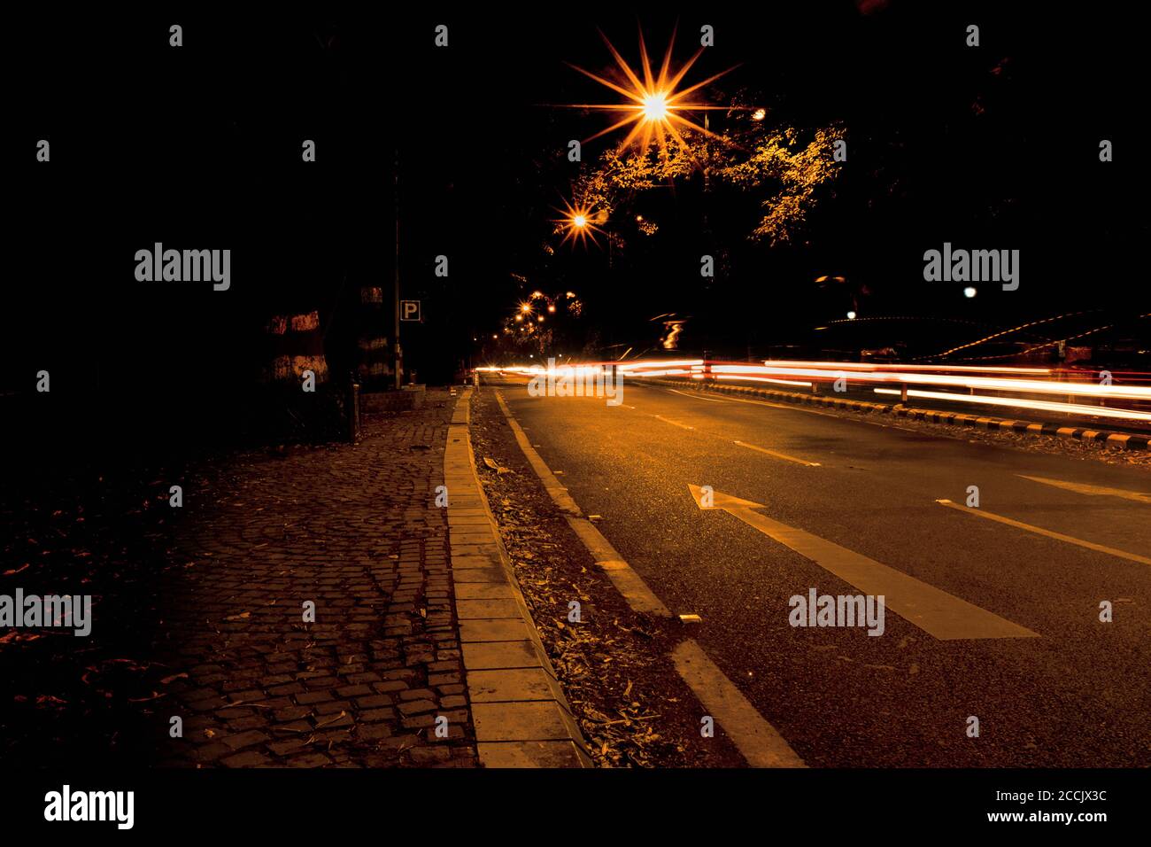 Langzeitaufnahme von Lichtspuren auf einer leeren Straße In der Nacht Stockfoto