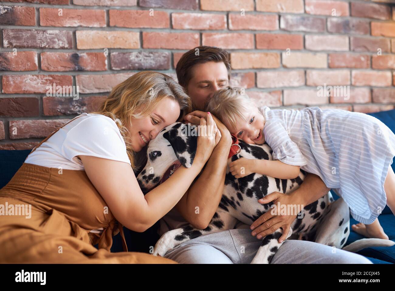 Jedes Mitglied der Familie lieben Haustier dalmatinischen Hund, sitzen sie auf dem Sofa umarmt ihr Haustier Stockfoto