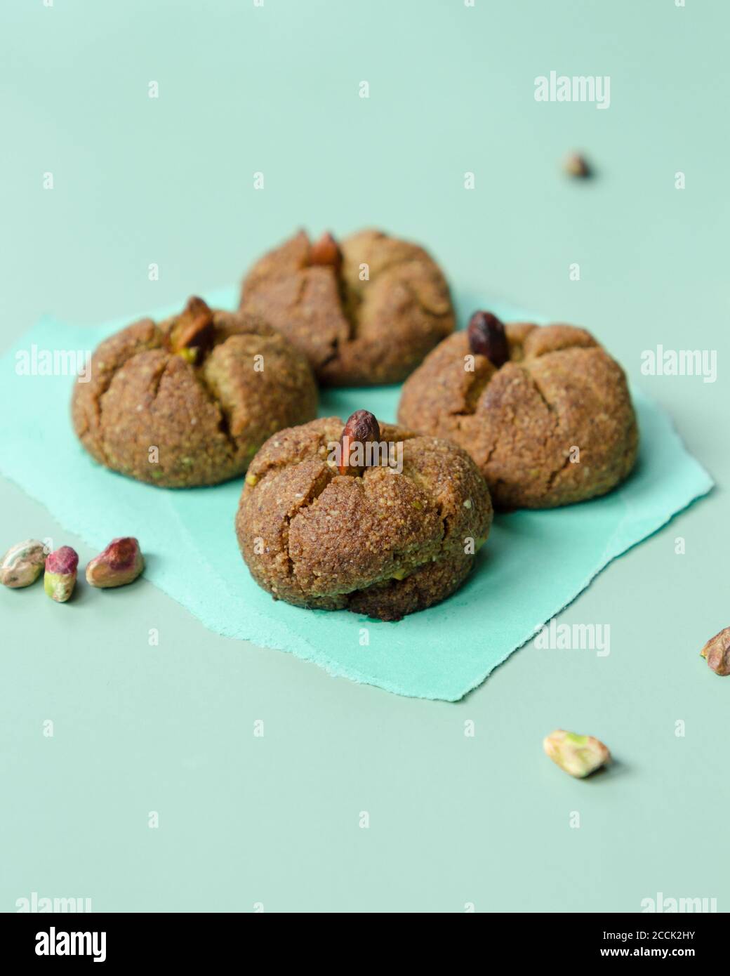 Traditionelle hausgemachte marokkanische festliche Ghoriba Cookies mit Pistazien Nüsse auf trendigen minzfarbenen Hintergrund. Stockfoto