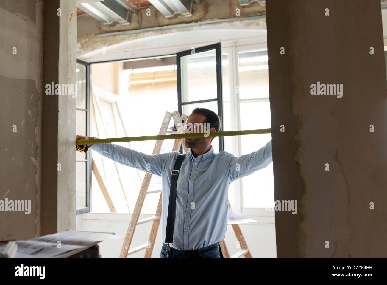 Architekt mit Maßband in einem Haus im Bau Stockfoto