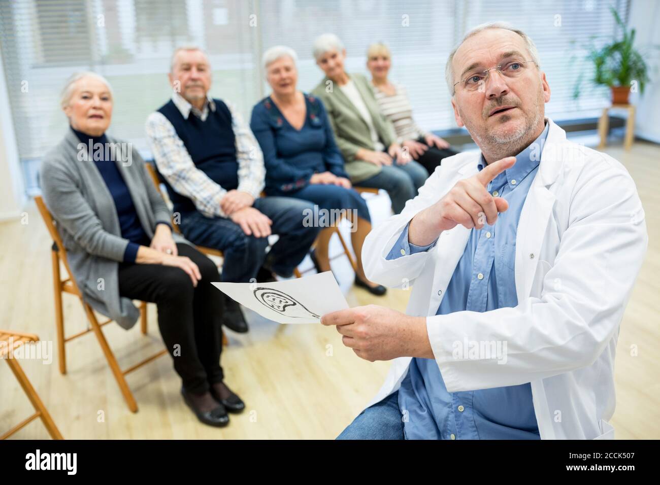 Gruppe von Senioren, die Gesundheitsberatung im Altersheim besuchen Stockfoto