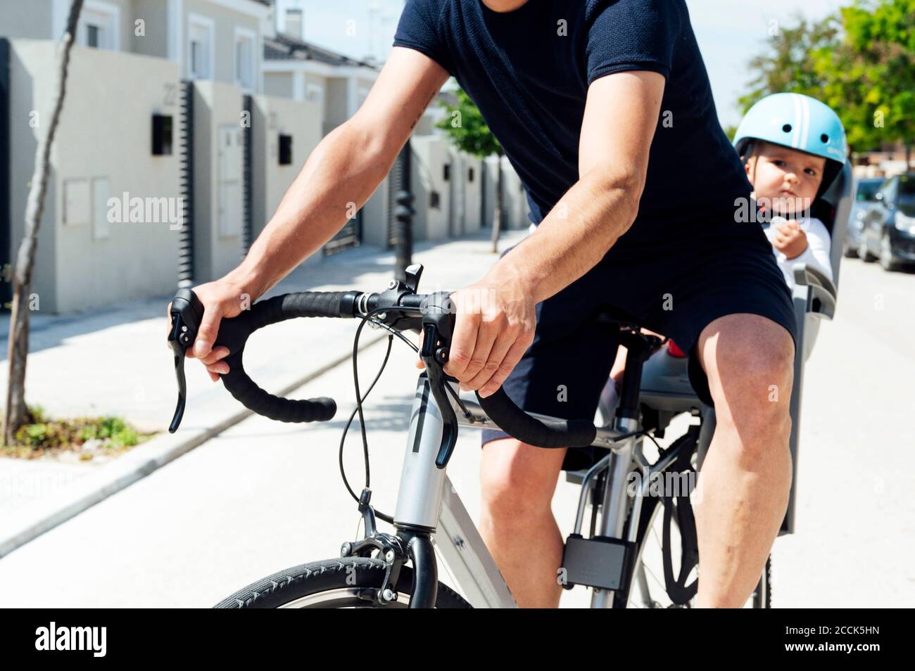 Vater mit Sohn sitzt in der Sicherheit Sitz des Fahrrads Stockfoto