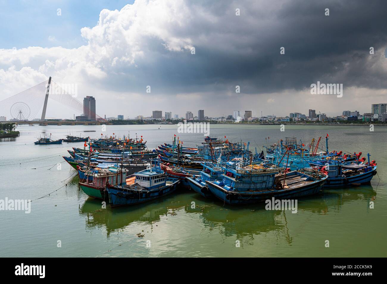 Vietnam, Da Nang, Sturm Wolken über alten Fischerbooten im Stadthafen festgemacht Stockfoto