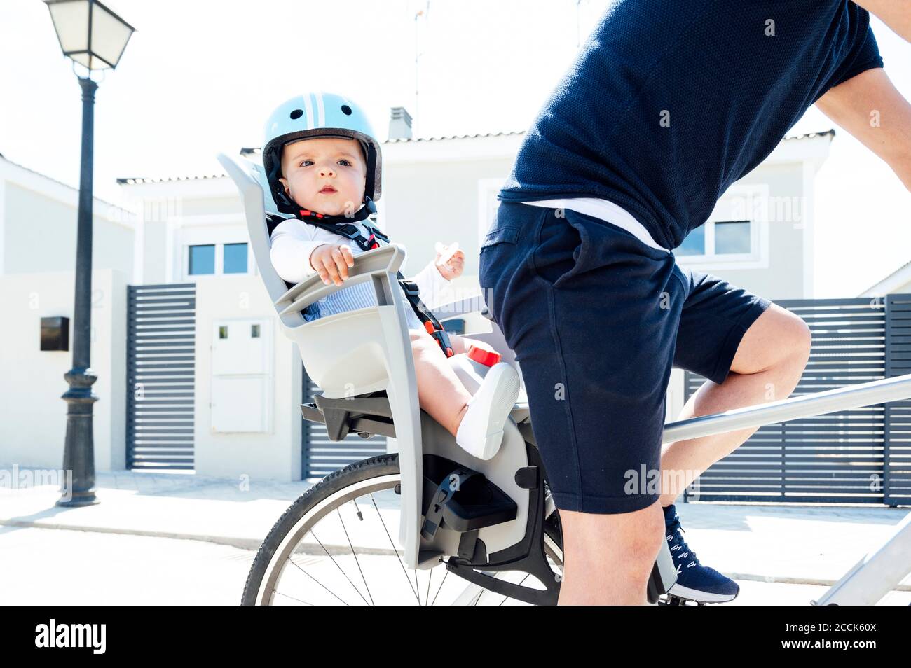 Vater mit Sohn sitzt in der Sicherheit Sitz des Fahrrads Stockfoto