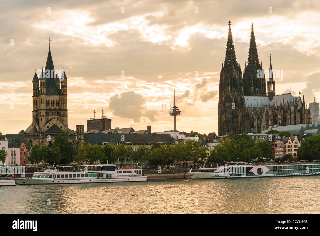 Deutschland, Nordrhein-Westfalen, Köln, Tourboote vor der Großen Martin Kirche und dem Kölner Dom in der Abenddämmerung Stockfoto
