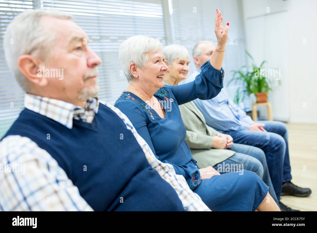 Senioren, die an einer Gruppenveranstaltung im Altersheim teilnehmen Stockfoto