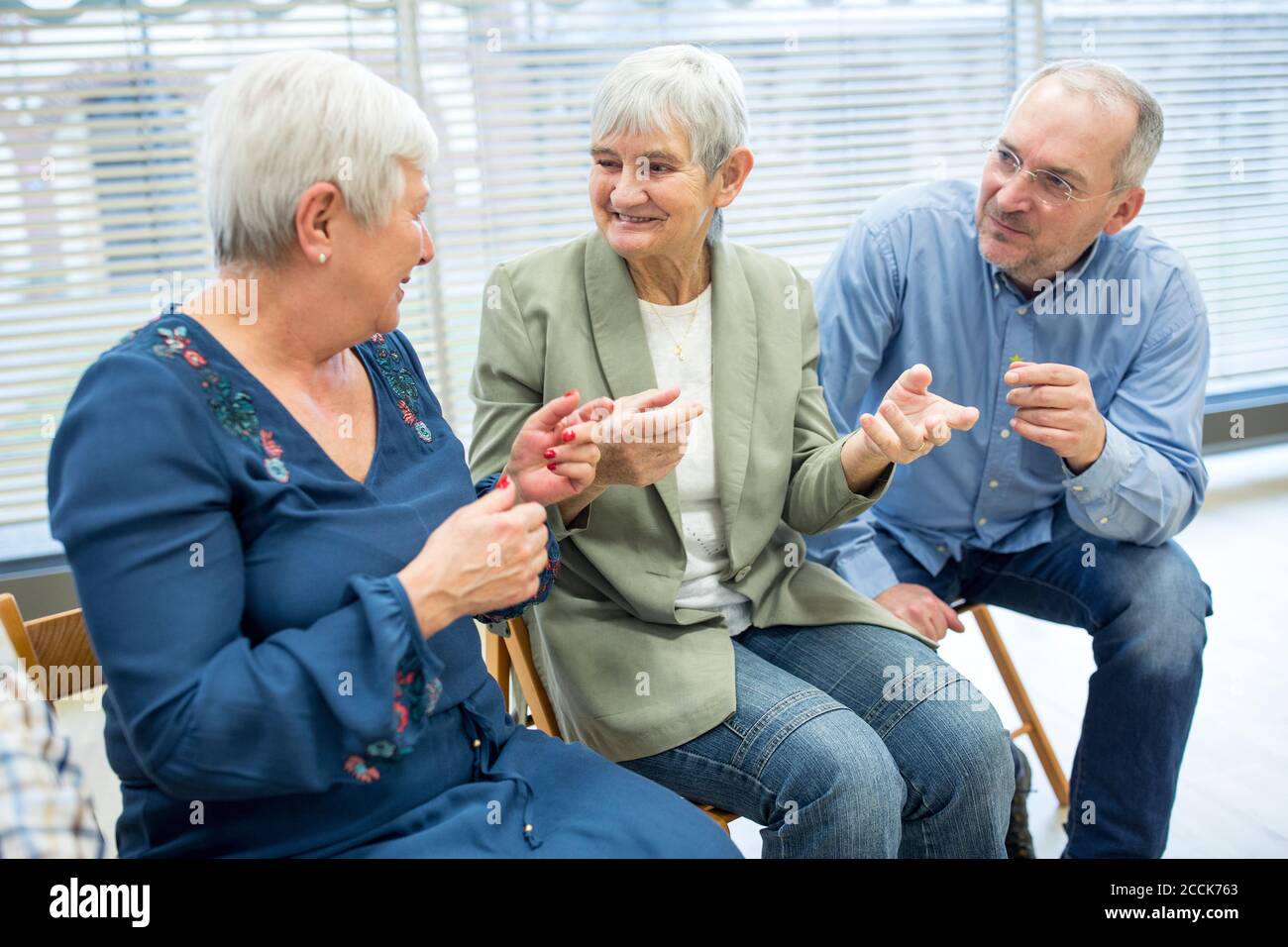 Senioren, die an einer Gruppenveranstaltung im Altersheim teilnehmen Stockfoto