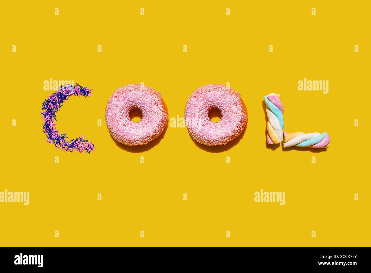 Zuckerstreuseln, Donuts und Marshmallows in einem einzigen Wort angeordnet Stockfoto