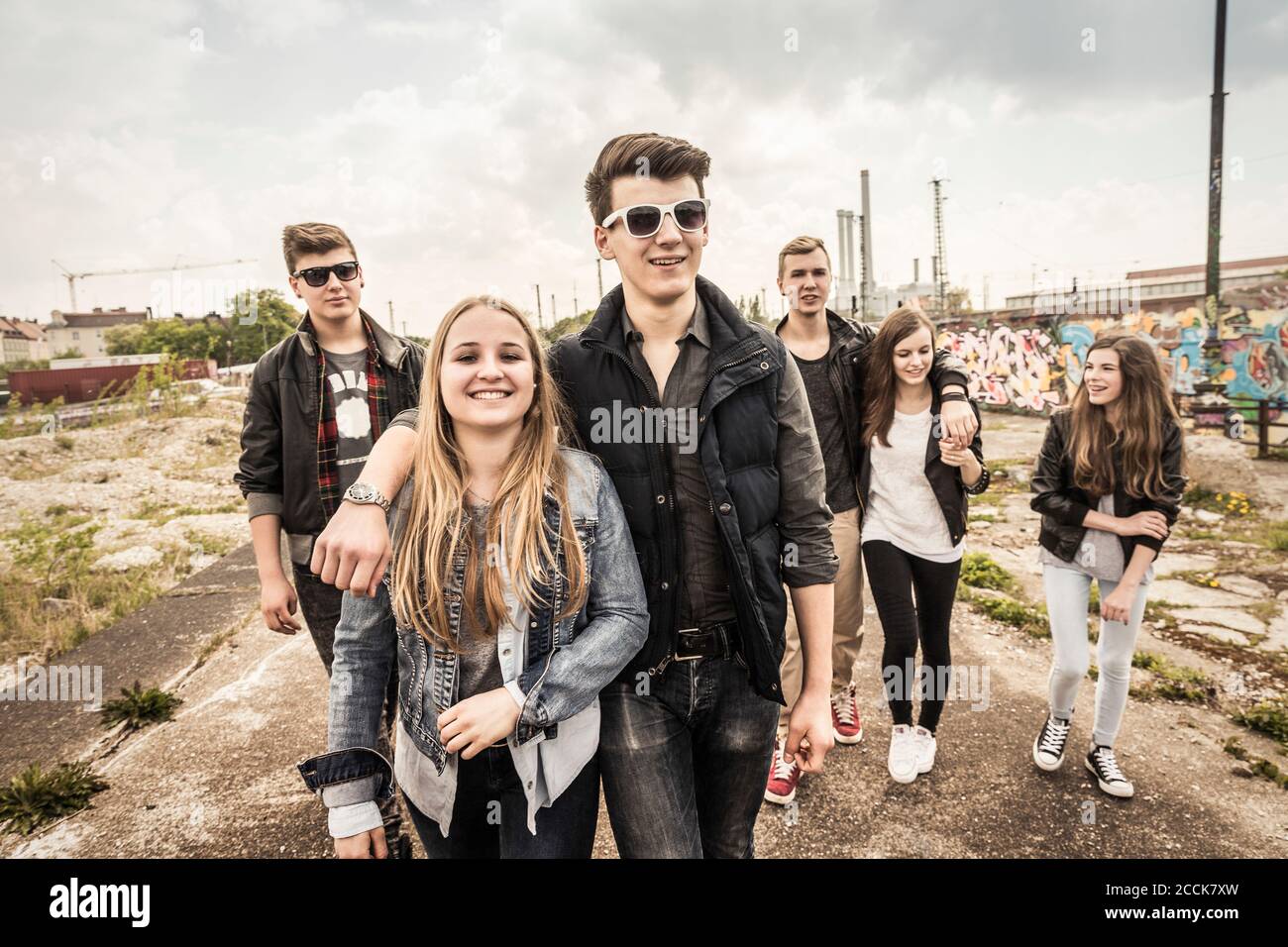 Eine Gruppe von Freunden, die in einem alten heruntergekommenen Hotel rumhängen Industriegebiet Stockfoto