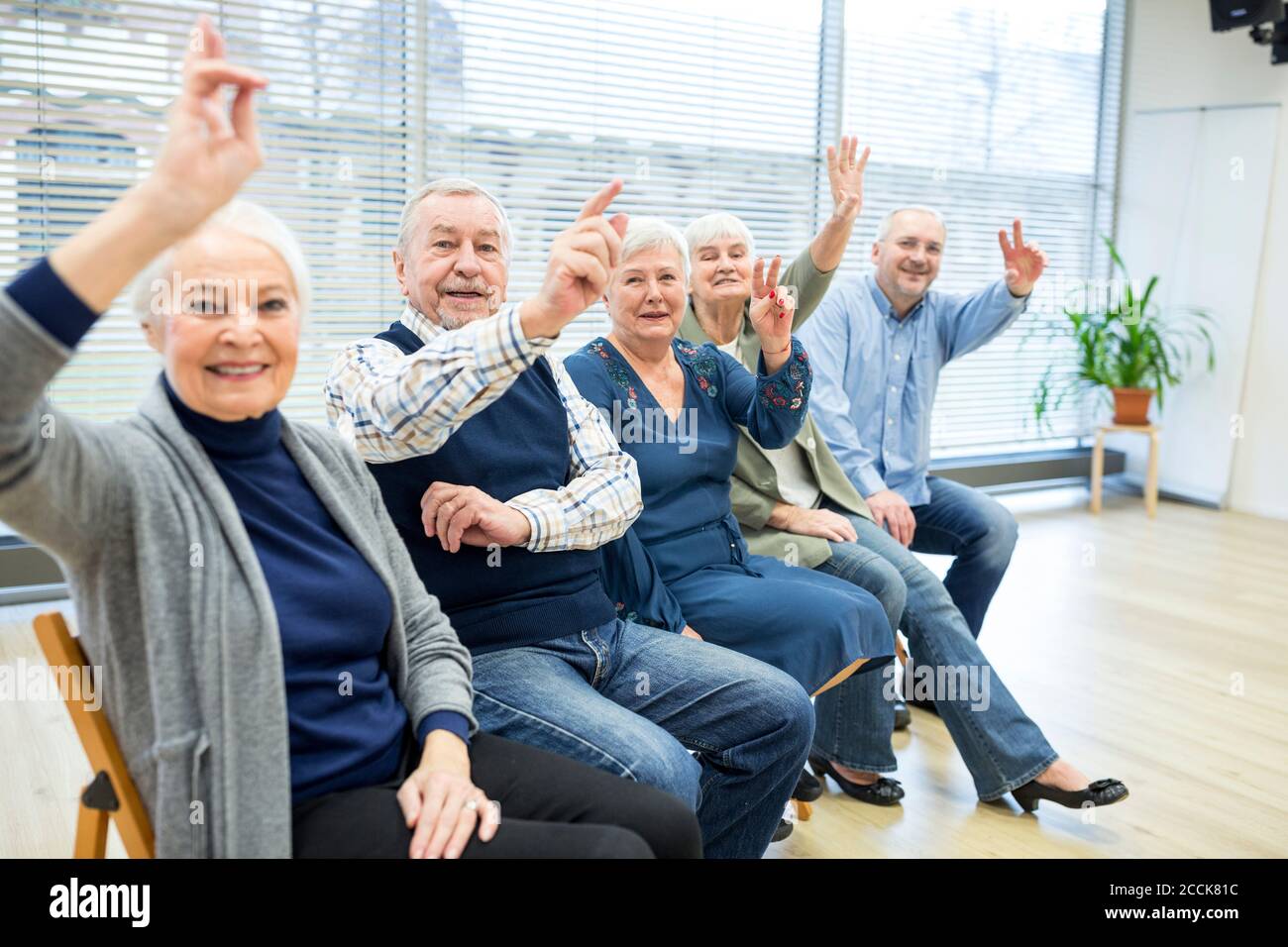 Senioren, die an einer Gruppenveranstaltung im Altersheim teilnehmen Stockfoto