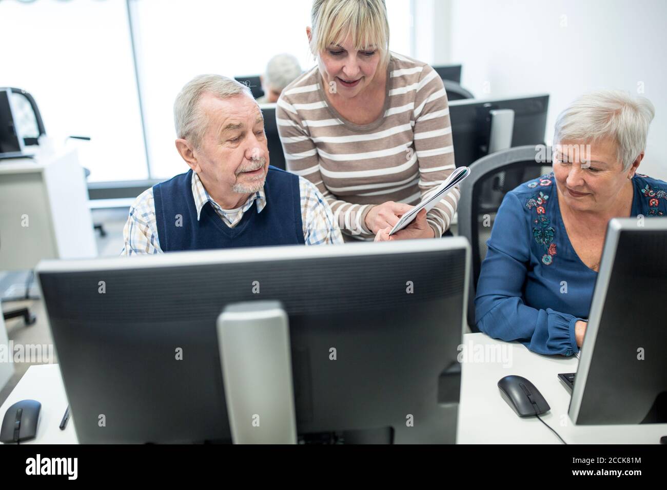 Aktive Senioren Teilnahme Computer-Kurs, intructor geben Beratung Stockfoto