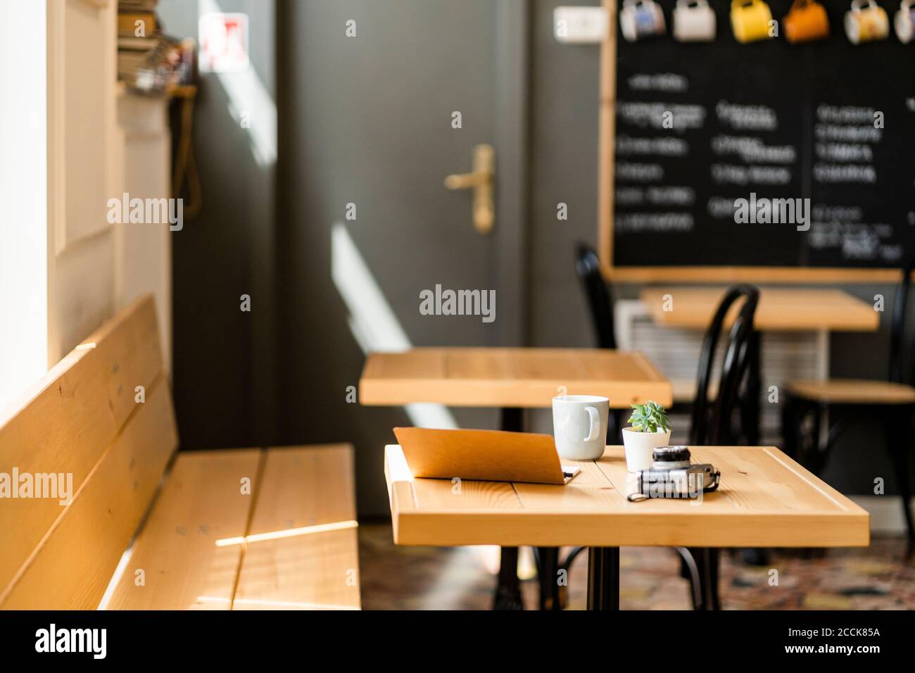 Buch und Kamera auf Holztisch im modernen Café Stockfoto