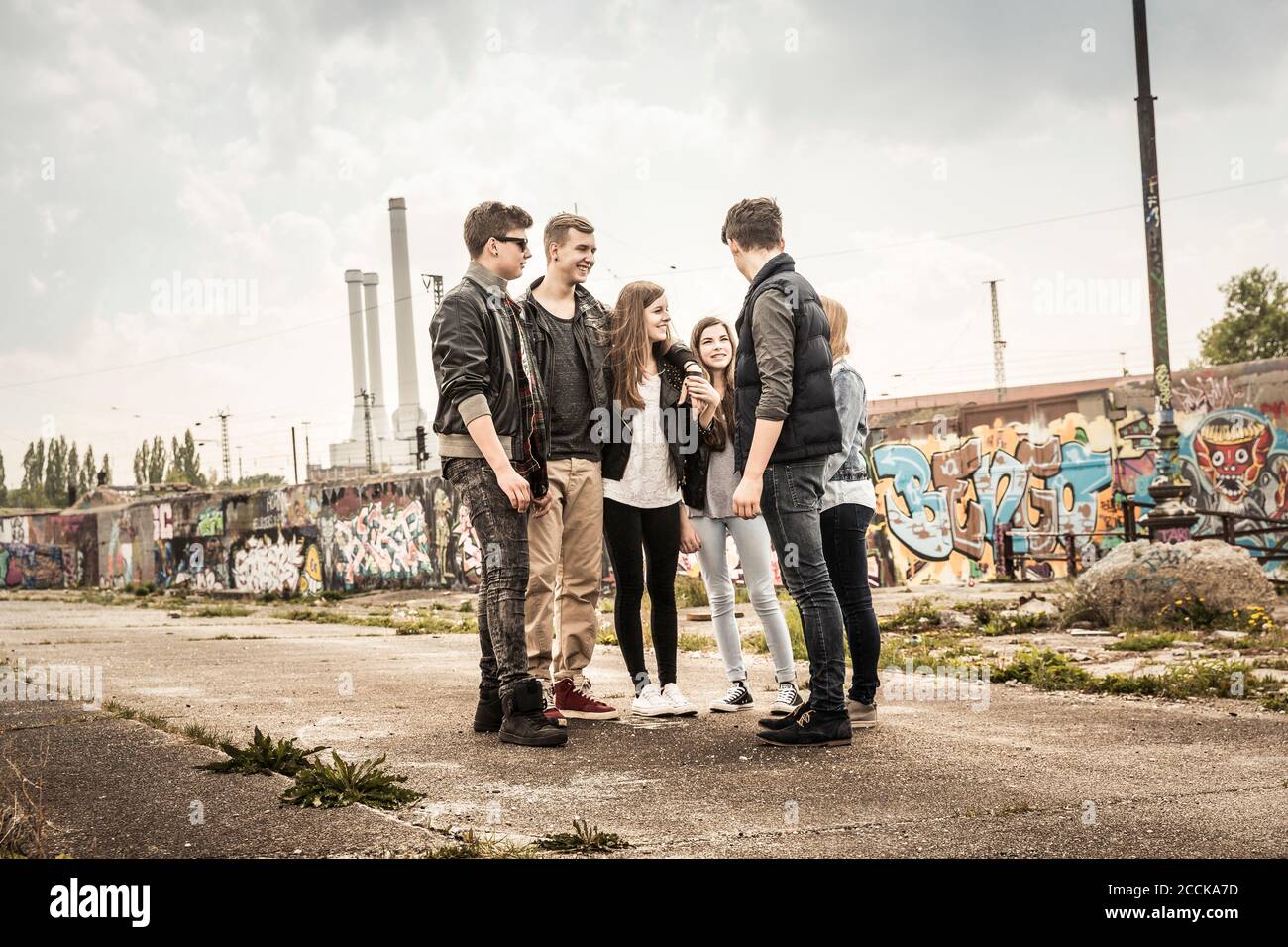 Eine Gruppe von Freunden, die in einem alten heruntergekommenen Hotel rumhängen Industriegebiet Stockfoto