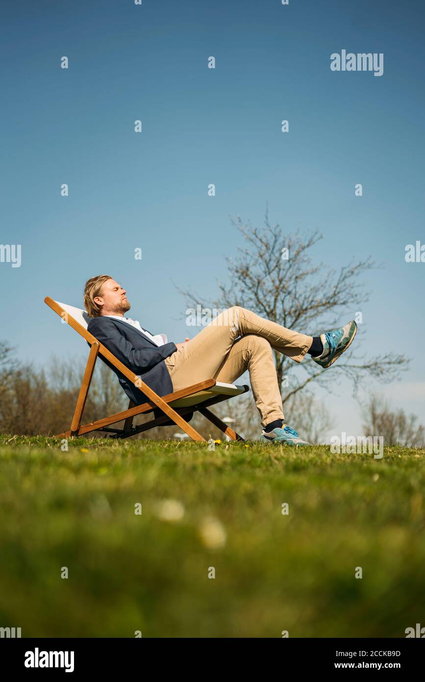 Blick auf die Oberfläche des männlichen professionellen Entspannung auf Stuhl parken Sie an sonnigen Tagen Stockfoto