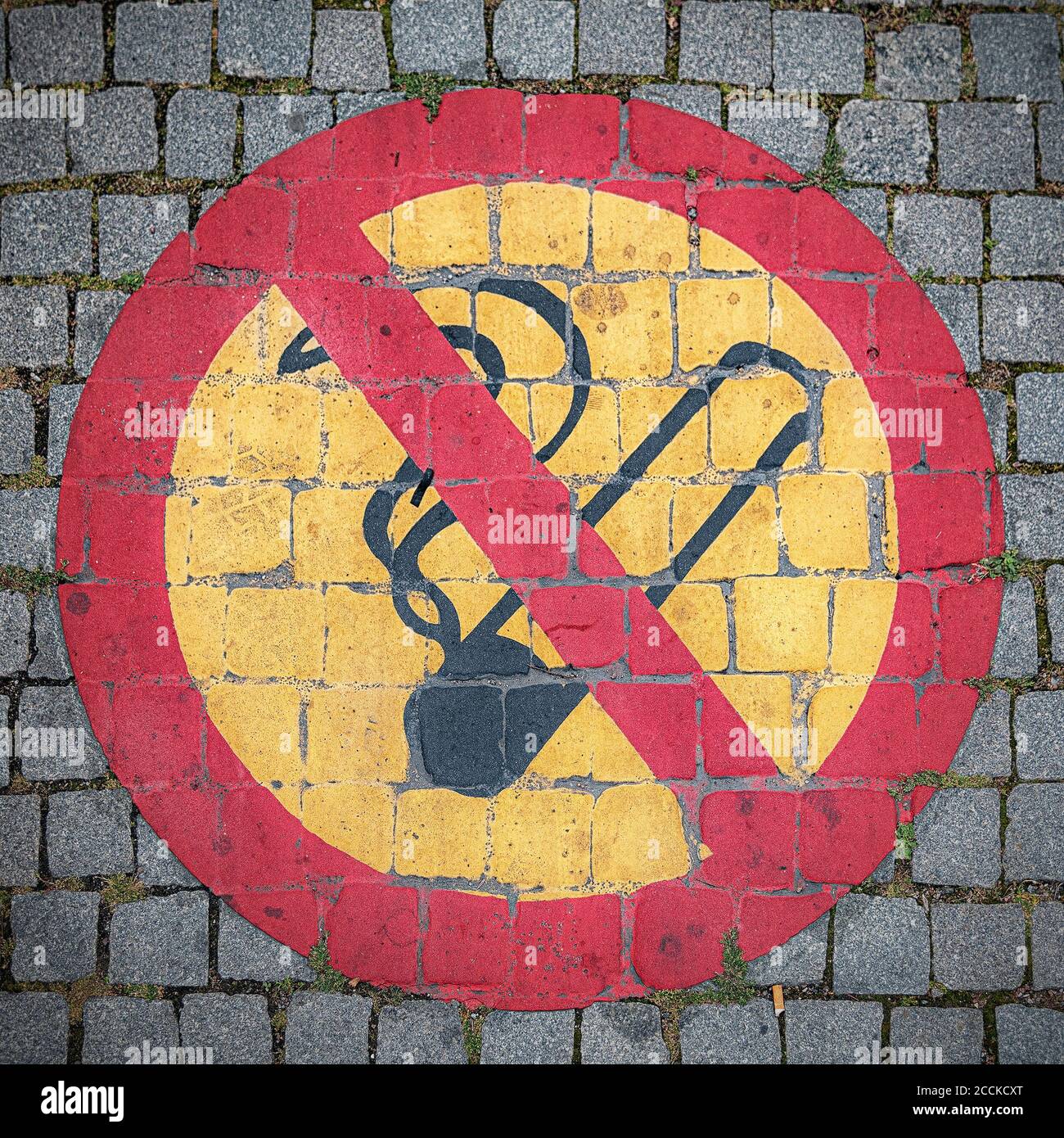Ein Rauchverbot auf Kopfsteinpflaster vor einem Gebäude. Stockfoto