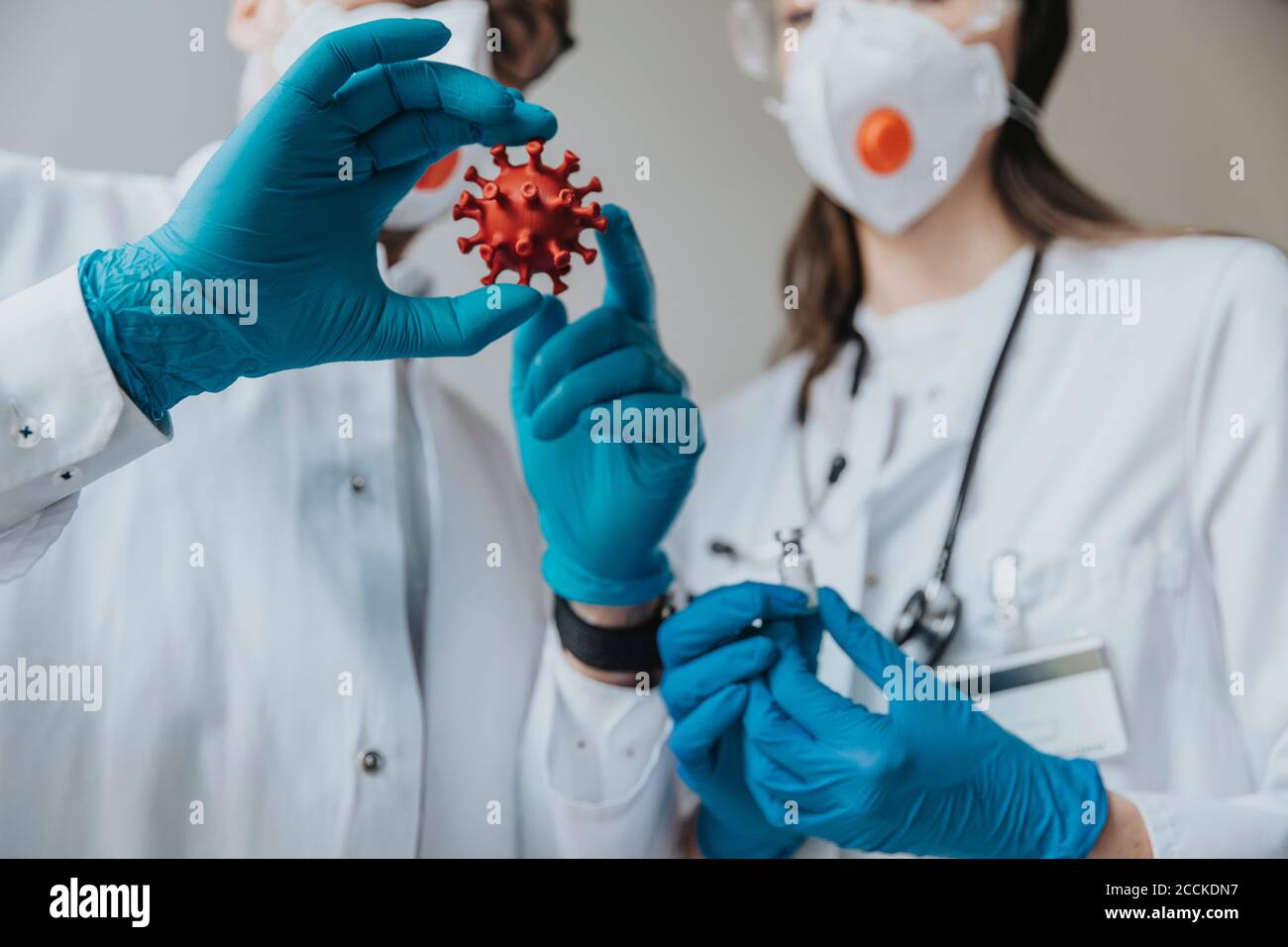 Ärzte halten Modell der biologischen Zelle und Impfstoff im Krankenhaus Stockfoto