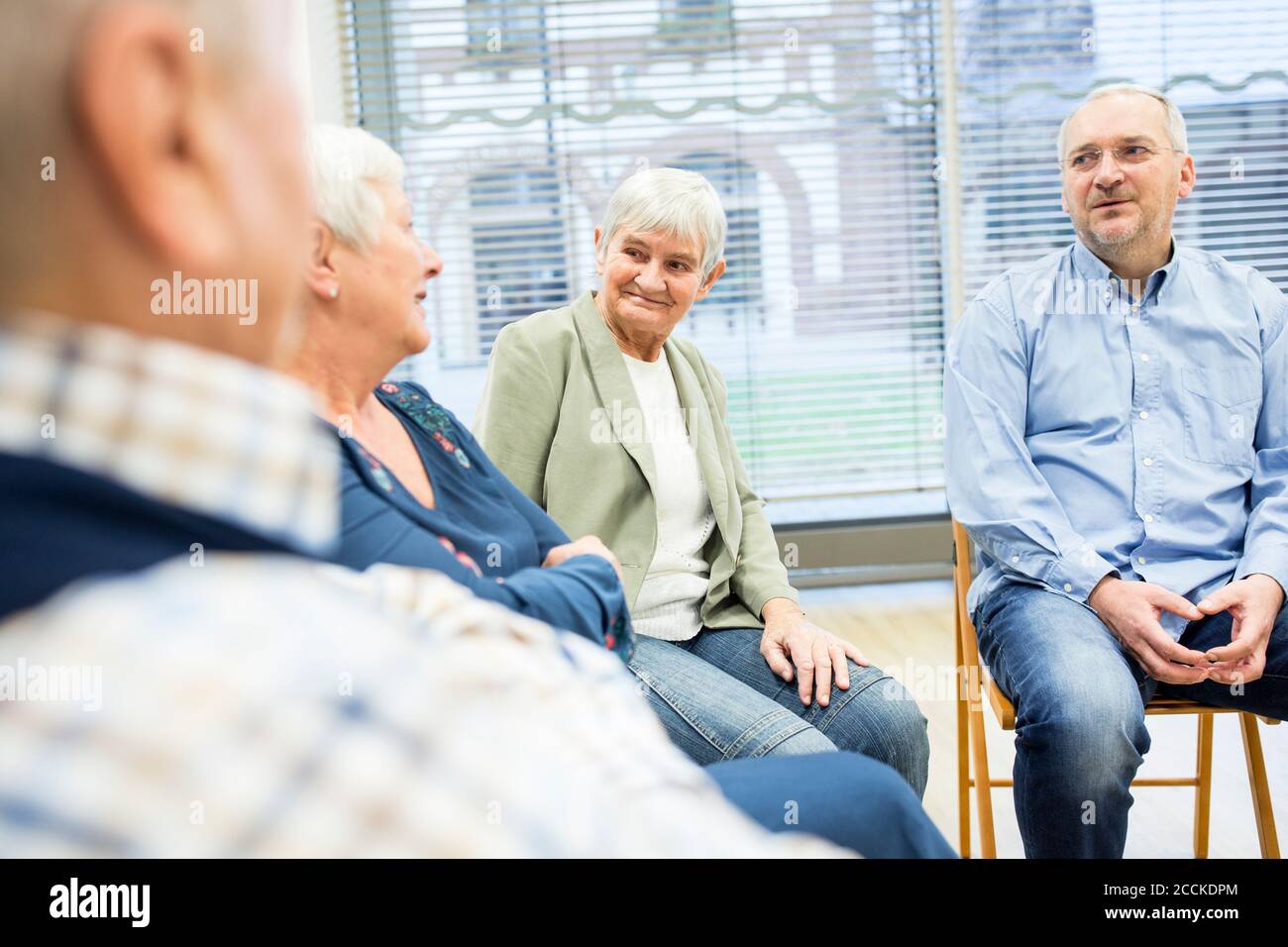 Senioren, die an einer Gruppenveranstaltung im Altersheim teilnehmen Stockfoto