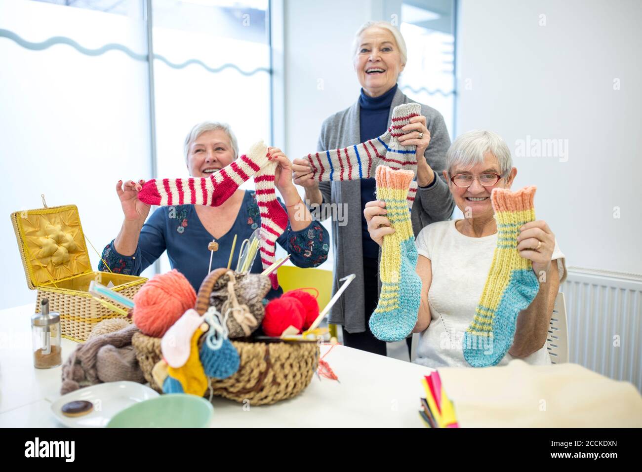 Ältere Frauen Stricken zusammen in Nadelarbeit Gruppe der Altersheim Stockfoto