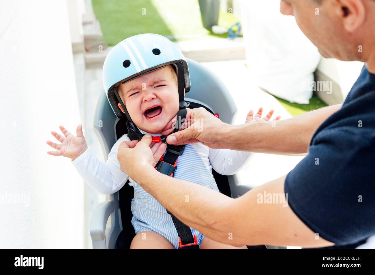 Vater mit Sohn sitzt in der Sicherheit Sitz des Fahrrads Stockfoto