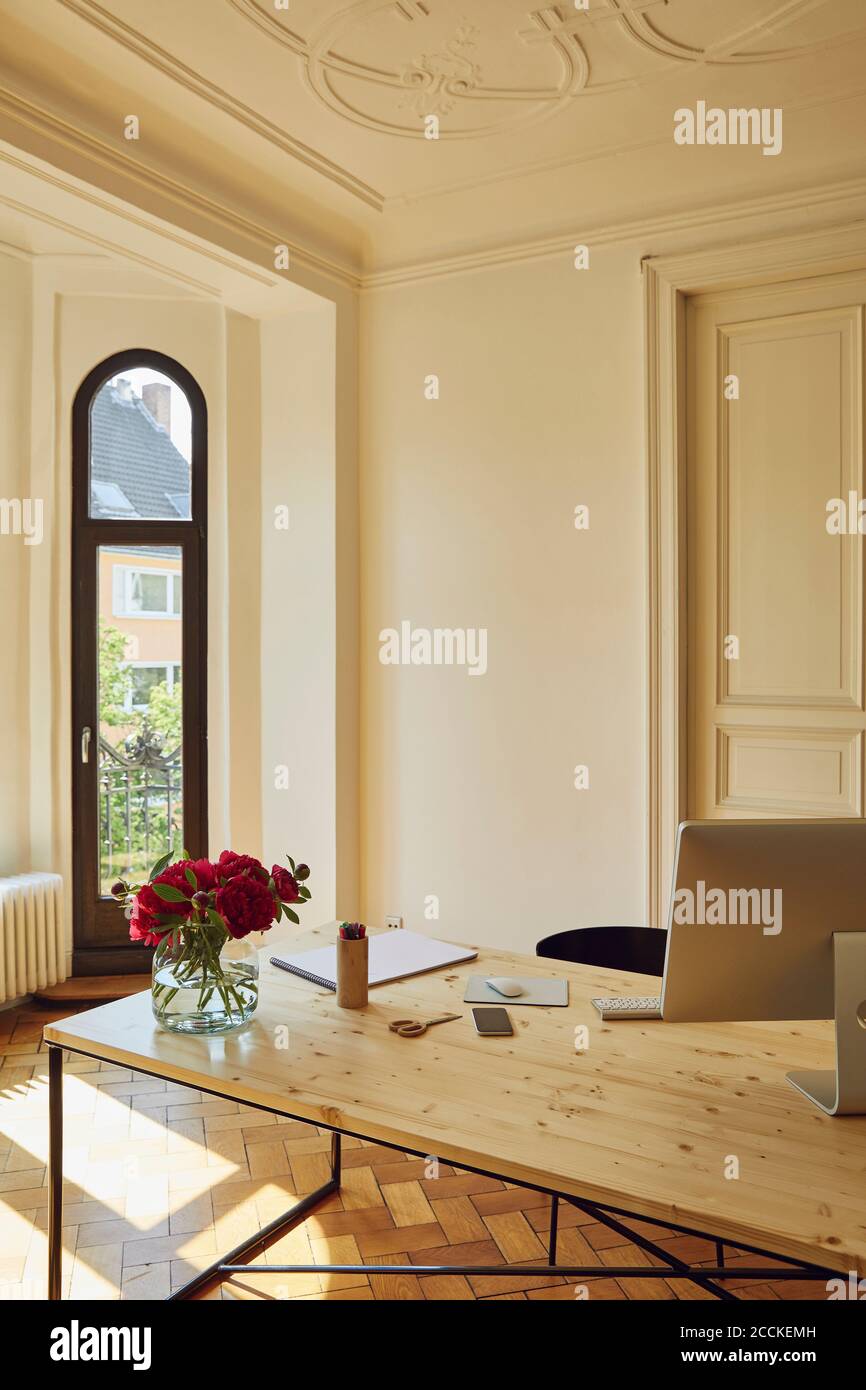 Leeres Home Office mit Computermonitor und Blumenvase Tabelle Stockfoto