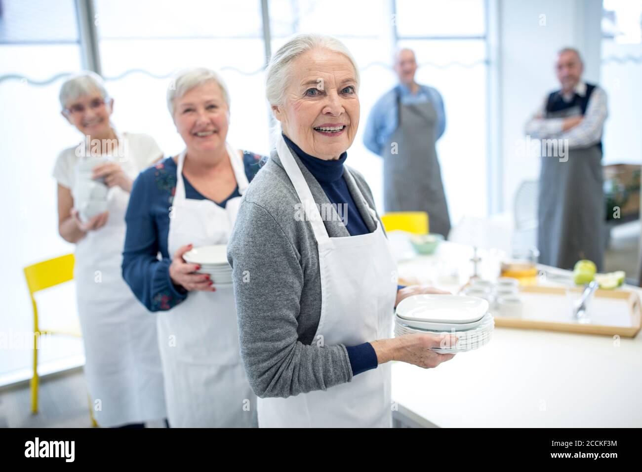 Gruppe von Senioren Legetisch für Kaffee-Party im Ruhestand Zu Hause Stockfoto