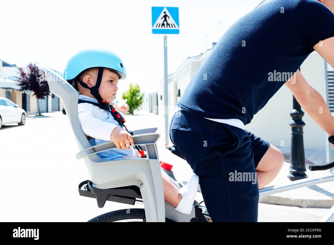 Vater mit Sohn sitzt in der Sicherheit Sitz des Fahrrads Stockfoto