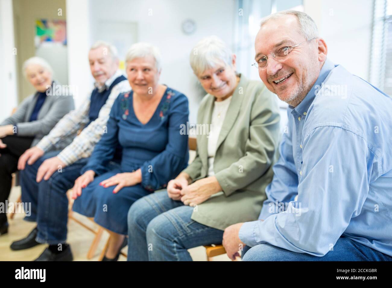 Senioren, die an einer Gruppenveranstaltung im Altersheim teilnehmen Stockfoto