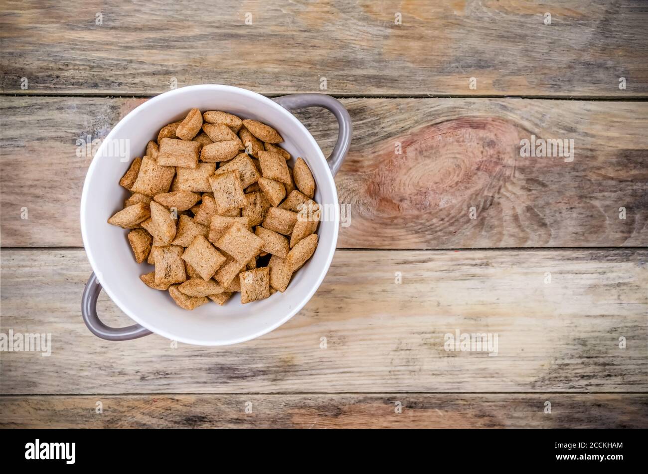 Schüssel mit süßen Maispfählen mit Schokolade innen auf einem Holzhintergrund, Kopierraum, Draufsicht Stockfoto