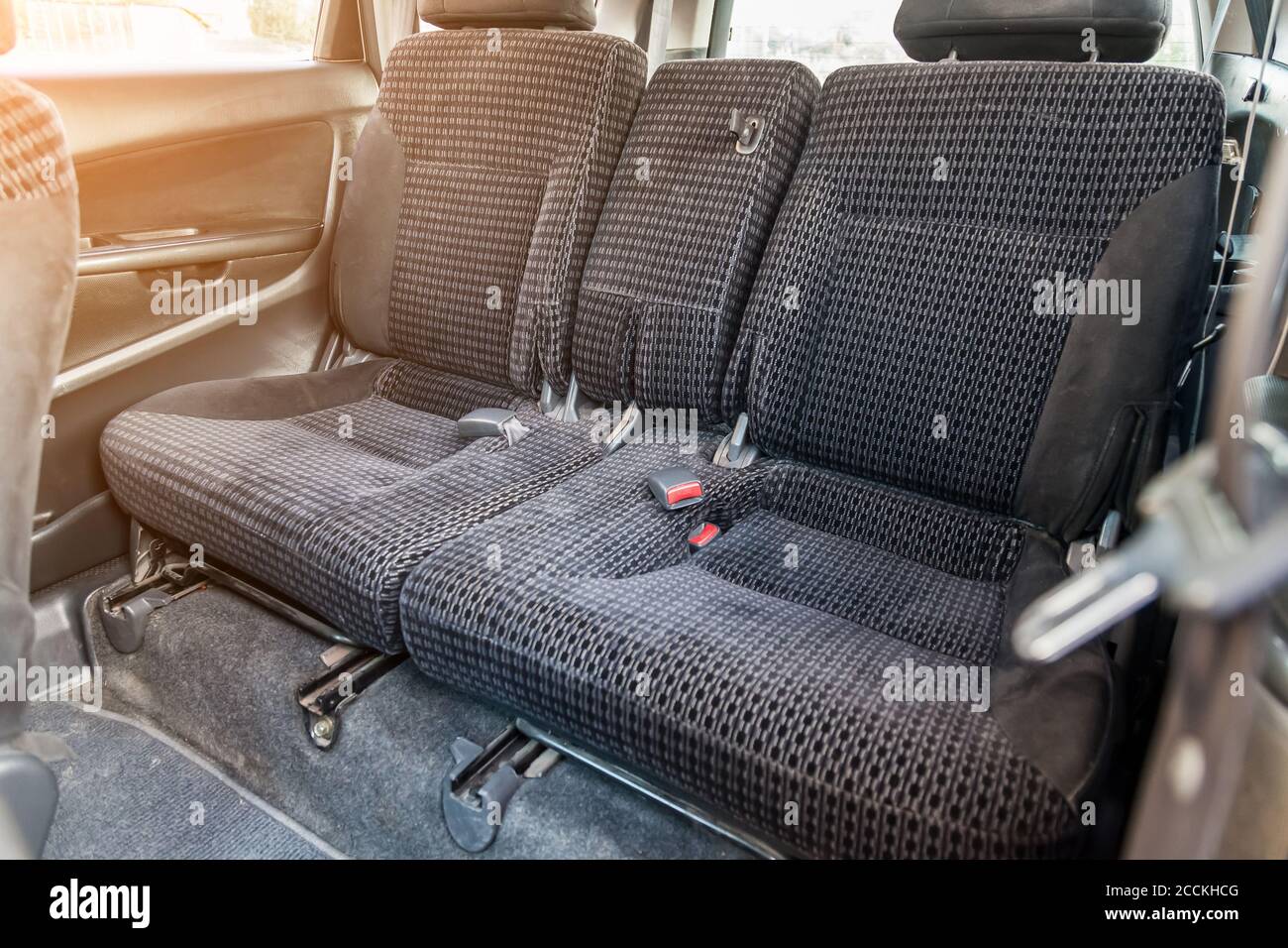 Reihe der Beifahrersitze mit dunkelgrauem, trocken gereinigtem Stoff bezogen; Vorbereitung eines alten japanischen Autos vor dem Verkauf. Stockfoto