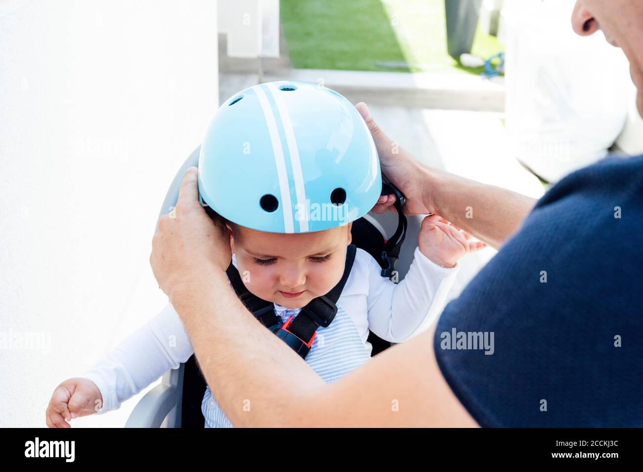 Vater mit Sohn sitzt in der Sicherheit Sitz des Fahrrads Stockfoto