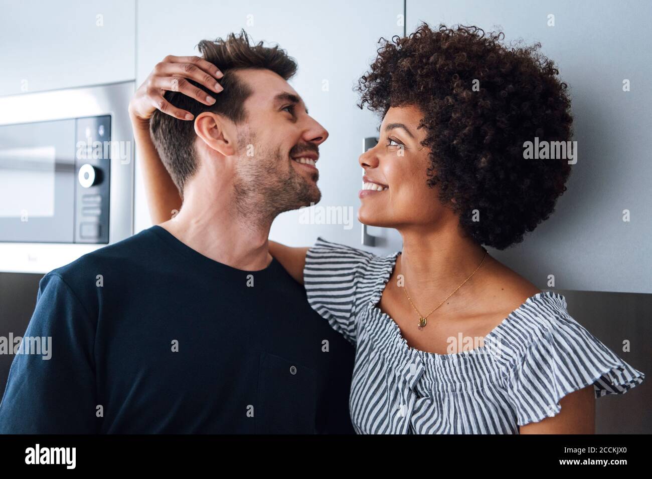 Glückliches multiethnisches Paar in der Küche Stockfoto