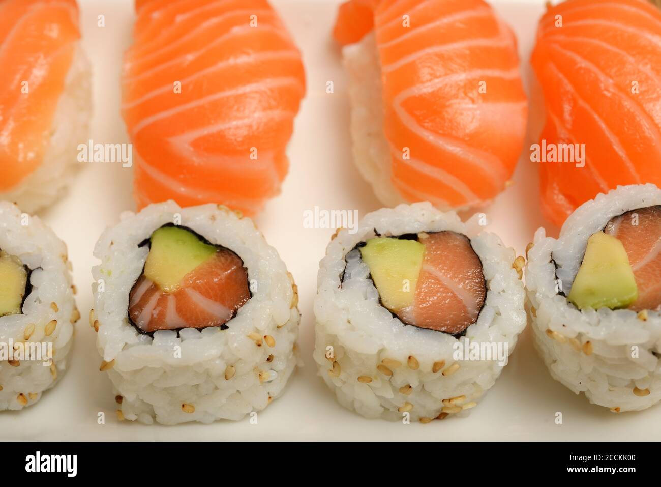 Sushi mit Lachs und Brötchen auf einem weißen Teller Stockfoto