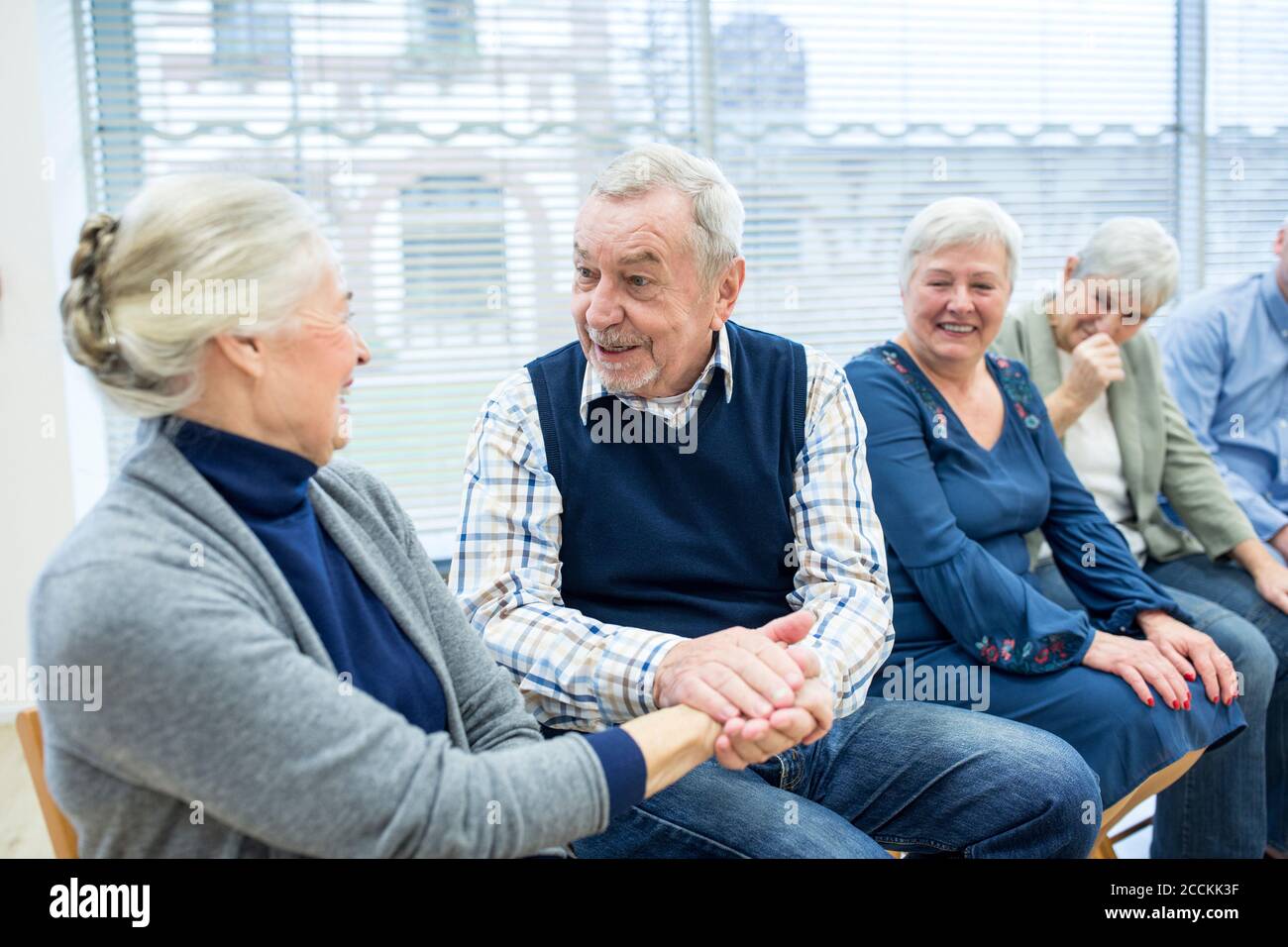 Senioren, die an einer Gruppenveranstaltung im Altersheim teilnehmen Stockfoto