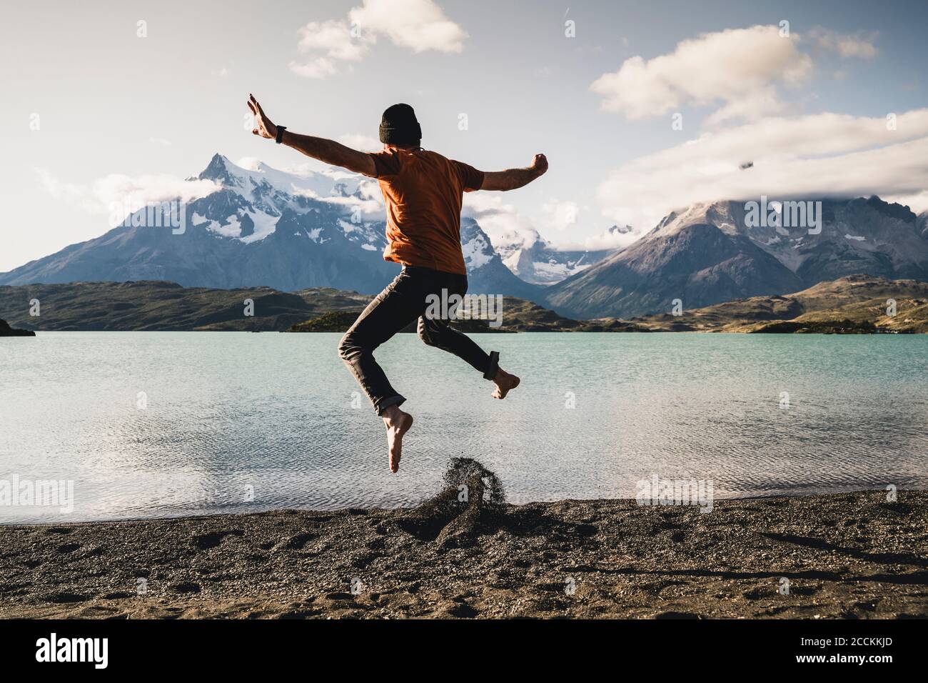 Mann mit ausgestreckten Armen springt am Lake Pehoe im Torres Del Paine National Park Patagonia, Südamerika Stockfoto
