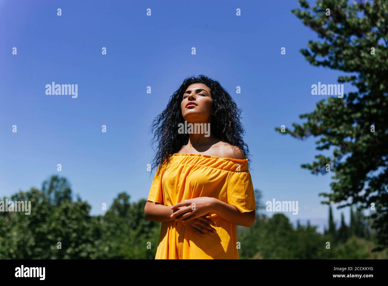 Porträt einer jungen schwarzhaarigen Frau, die die Sonne genießt Stockfoto